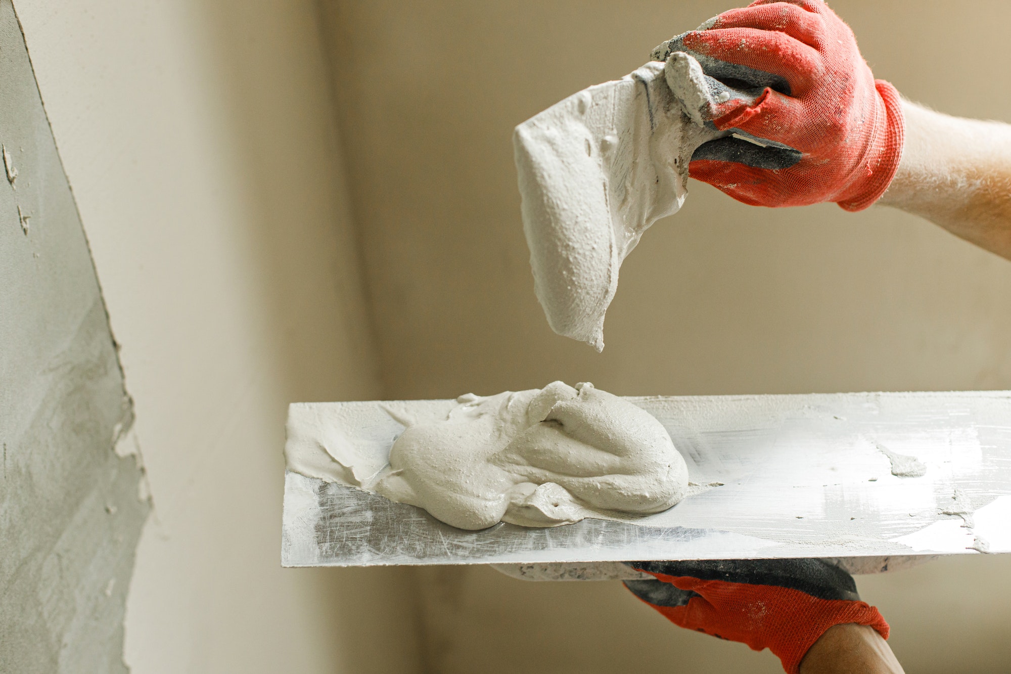 Handyman plastering walls with gypsum plaster and trowel